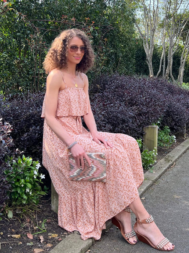 Introducing the Celena dress from Poppy Field The Label in a light brown pink colour. This Maxi dress features a fabric overlay over the chest area, self-tie waist line, floaty maxi skirt & twin spaghetti straps.