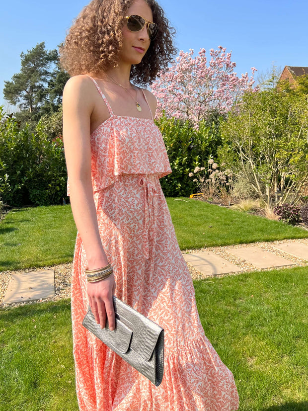 the Celena dress from Poppy Field The Label in a beautiful Coral shade. This Maxi dress features a fabric overlay over the chest area, self-tie waist line, floaty maxi skirt & twin spaghetti straps.