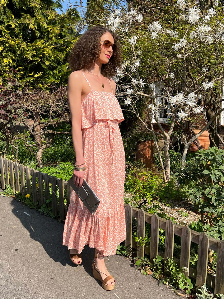 the Celena dress from Poppy Field The Label in a beautiful Coral shade. This Maxi dress features a fabric overlay over the chest area, self-tie waist line, floaty maxi skirt & twin spaghetti straps.